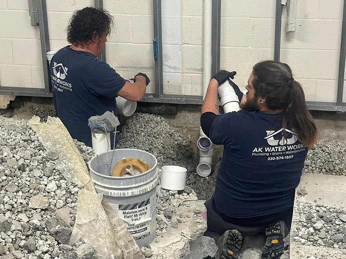 AK Water Works & HVAC plumbers repairing pipes on a job site